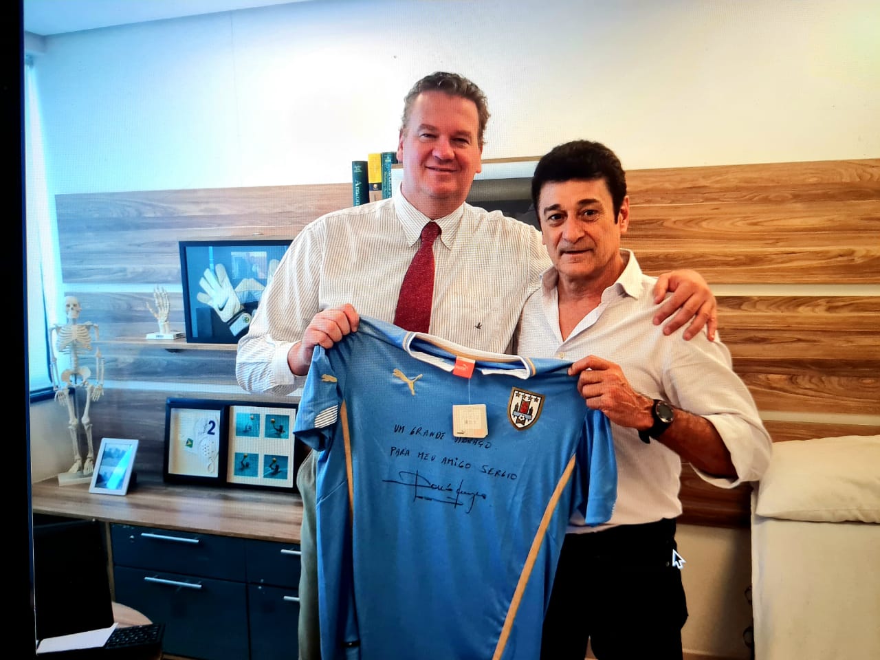 Dr. Sérgio ao lado de Dário Pereyra segurando uma camisa de futebol